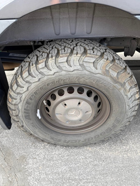 Close-up of an RV rental's durable BFGoodrich All-Terrain T/A KO2 tire and Mercedes wheel, showing its robust off-road tread.