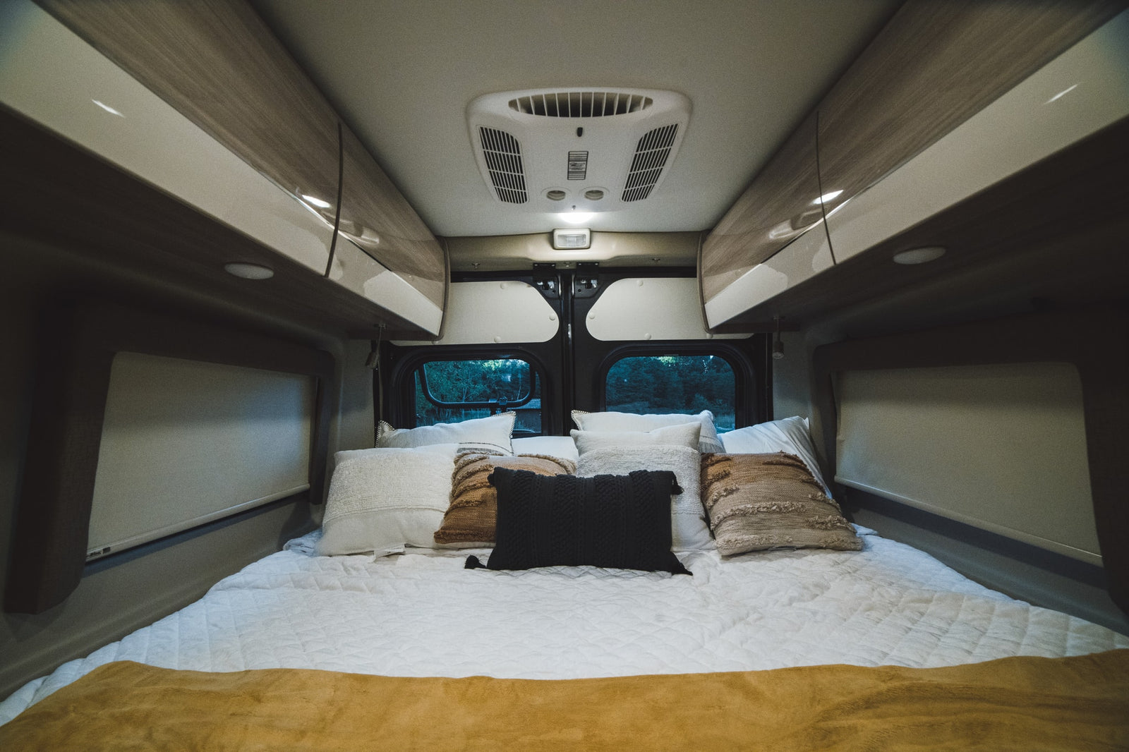  with an awning extended & pop-top raised.|Cozy RV rental bedroom featuring comfortable bedding
