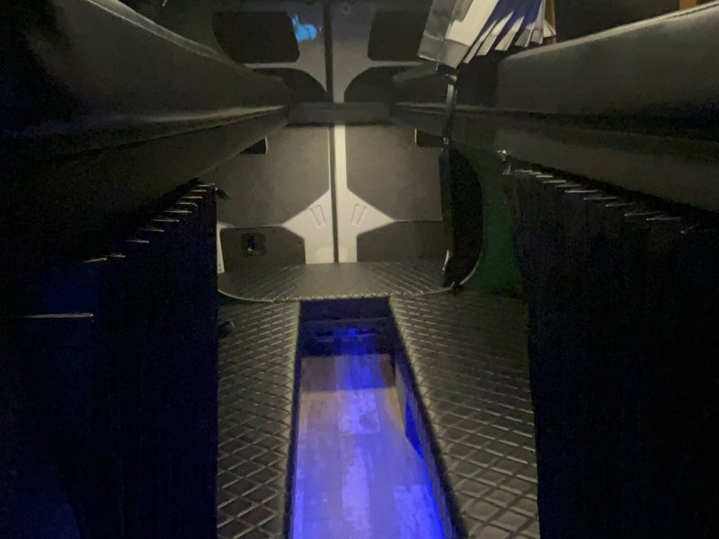  and vibrant blue LED strip lighting.|White Mercedes Sprinter rv rental parked on gravel — photo 4