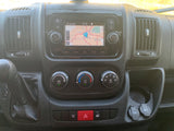 Inside an RV rental: a detailed dashboard with an active navigation screen showing Denver and accessible climate controls.