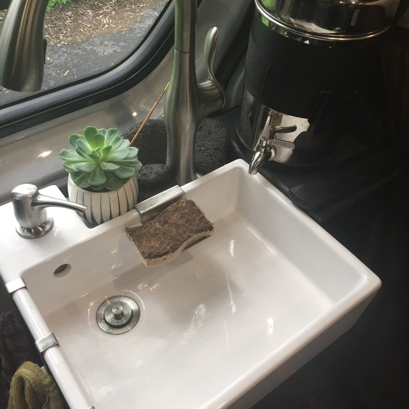 Bright sink with soap, sponge, and plant in an RV rental. Modern faucet and compact design for on-the-go living. — photo 7