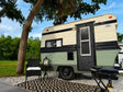 This charming RV rental features a cream and green vintage-style camper