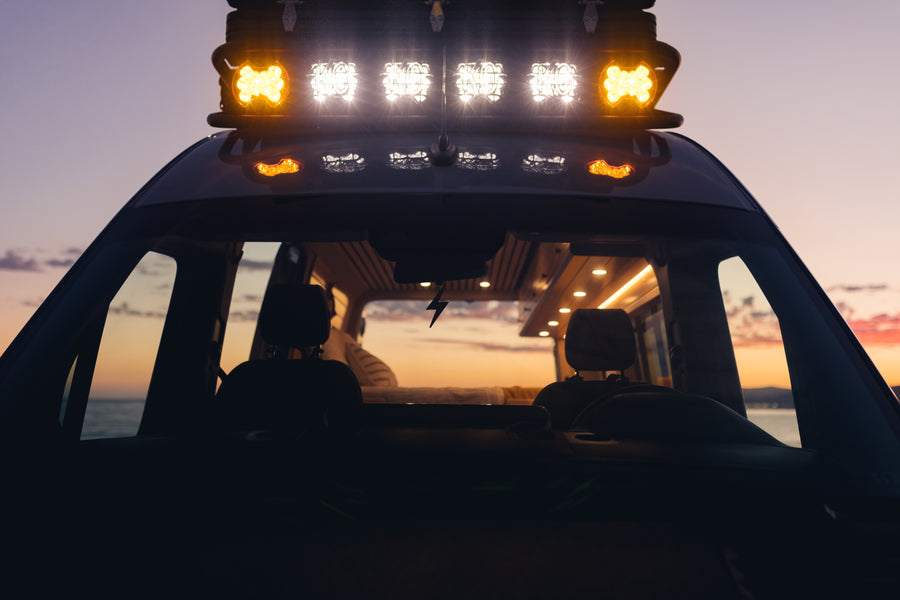 Experience a vibrant sunset from an **rv rental** van, showcasing its bright roof lights and comfortable interior.