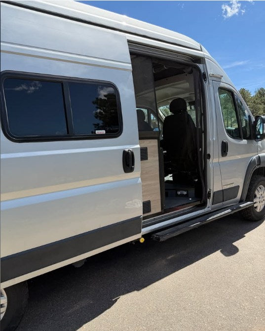 This silver rv rental camper van features an open side sliding door, revealing its interior, with an extended running board. — photo 15