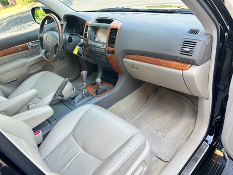 Clean Lexus GX SUV interior: wood, leather, navigation screen. Perfect for road trips, a spacious option alongside RV rental plans.