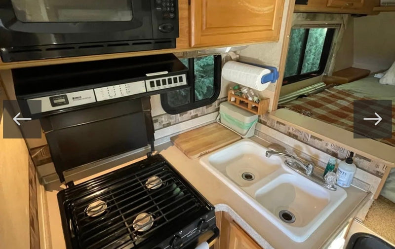  and overhead vent.|RV rental dinette area featuring two upholstered benches — photo 13