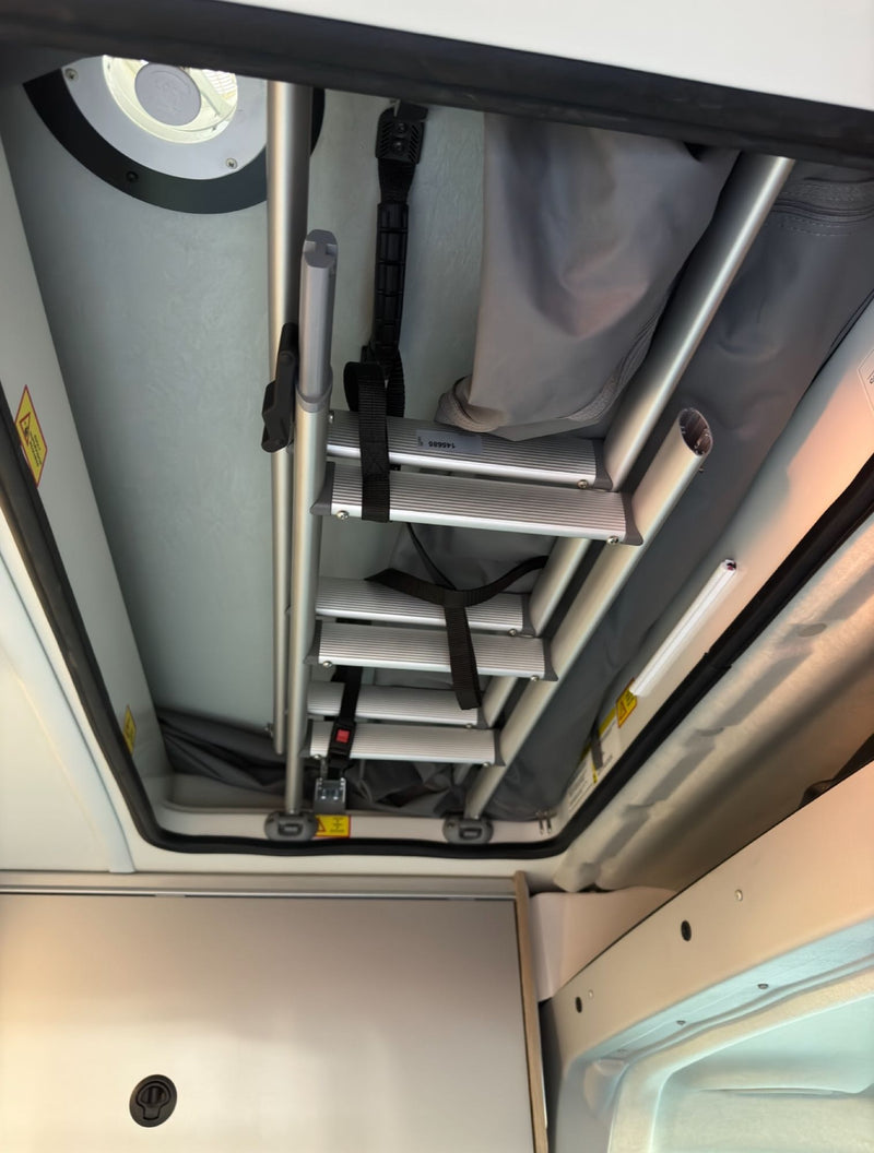  and AC unit for comfortable travel.|Inside an rv rental camper van: a raised bed — photo 14