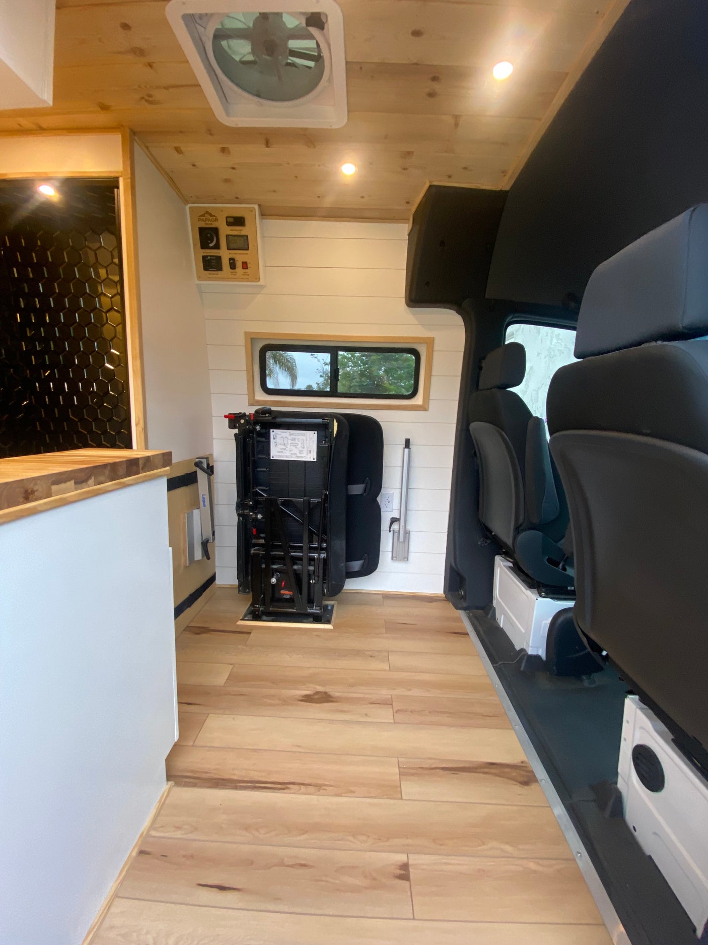 Step inside this stylish RV rental van with wood floors, shiplap walls, and versatile passenger seating.