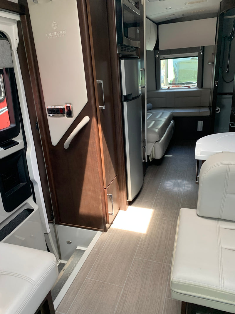  revealing comfortable interior steps and seating of a luxury camper van.|Inside a luxurious RV rental: open side door with screen — photo 9