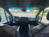 Inside a spacious Mercedes RV rental. View of the dashboard, steering wheel, and front seats from the rear.
