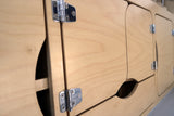 RV rental interior showcasing light wood cabinets, chrome hinges, and unique cut-out handles.