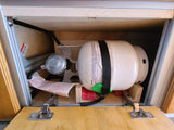 RV rental cabinet with a securely stored propane tank and regulator, essential for camper use.
