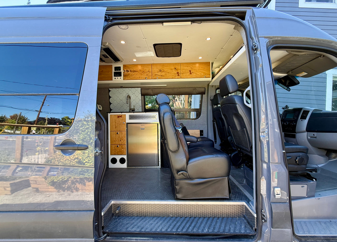 Spacious RV rental interior showcasing a custom kitchen, comfortable seating, and smart storage, perfect for travel.