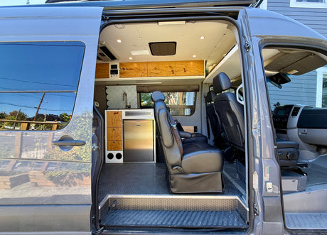 Spacious RV rental interior showcasing a custom kitchen, comfortable seating, and smart storage, perfect for travel.