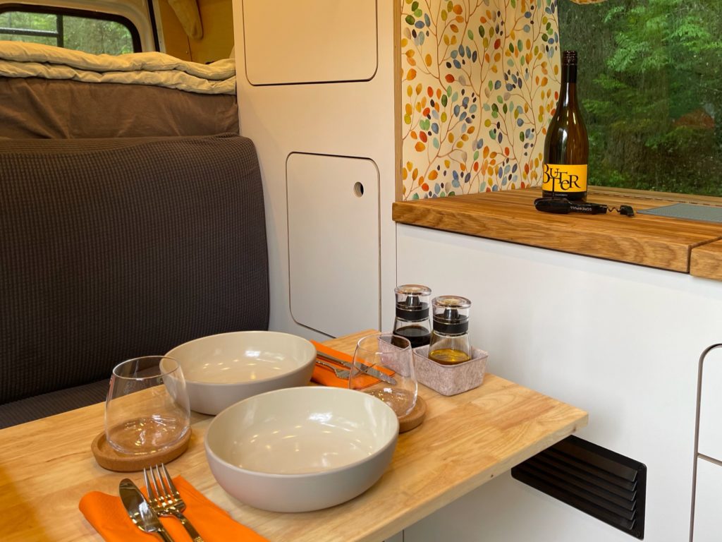  and beautiful nature view out the open doors.|White RV rental van facing Golden Gate Bridge in San Francisco. Ready for your next travel adventure under a clear sky.|Enjoying a stunning ocean view from a cozy RV rental. Perfect for your next Pacific Coasting adventure!|White camper van (RV rental) with open side door showing modern interior — photo 5