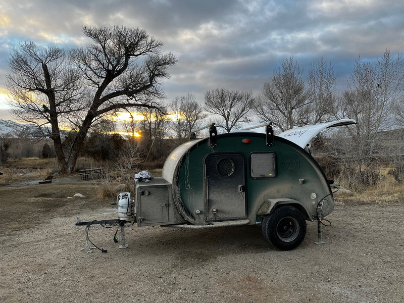 dark green teardrop camper is set up at a scenic campsite during sunset — photo 10