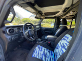 Interior of a versatile Jeep rental with blue camo seats and open roof for scenic adventures. A great RV rental alternative.