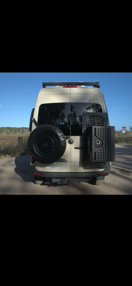 Tan Mercedes Sprinter rv rental van, rear view, equipped with a mounted spare tire and storage box, ready for adventure.