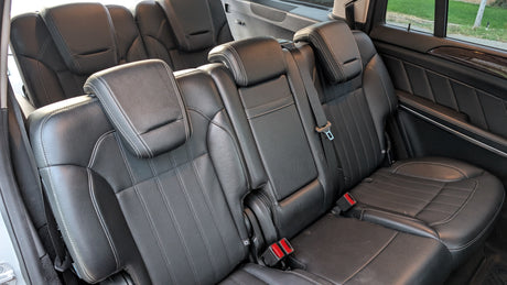 Clean black leather car seats and headrests in a spacious vehicle interior, ready for your next road trip or rv rental.