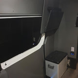 RV rental van conversion: Dark gray interior with large window, portable fridge, power outlets, and open overhead storage.