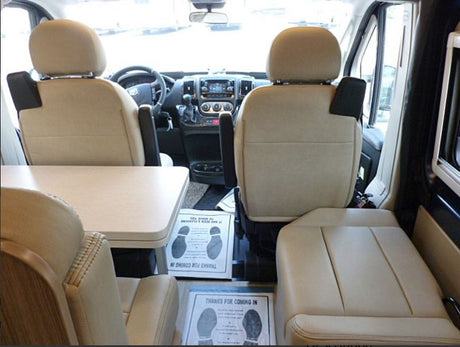RV rental interior: Swiveled front seats face a table and rear seating, creating a cozy camper van living area.