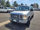 Silver Colorado Ford van at an RV rental lot, with other vans and RVs visible in the background.