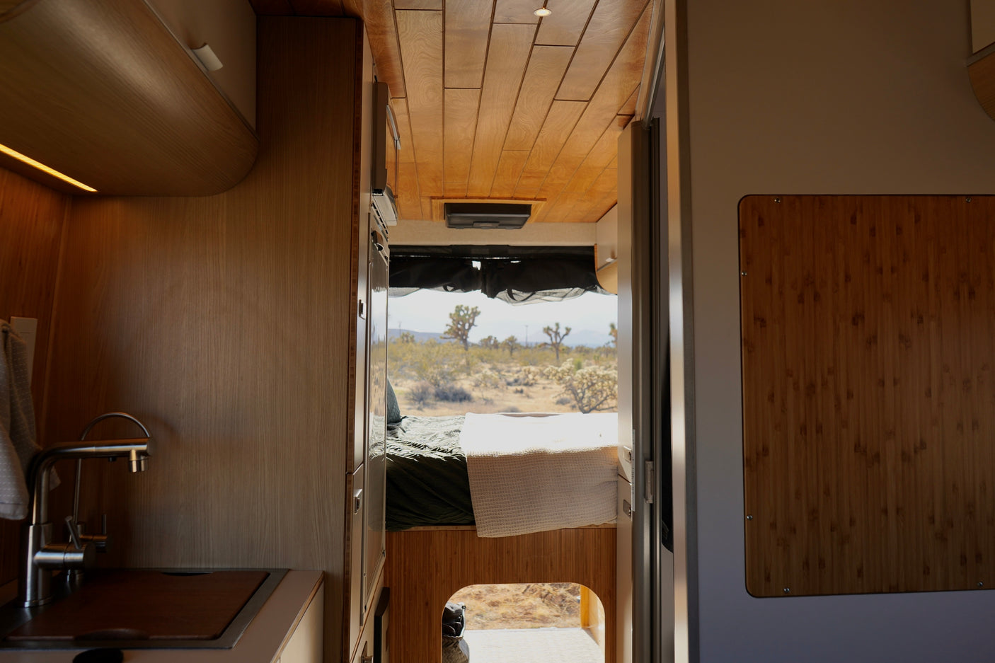 Experience an RV rental with a cozy interior, kitchenette, and bedroom, offering desert views perfect for your next adventure.