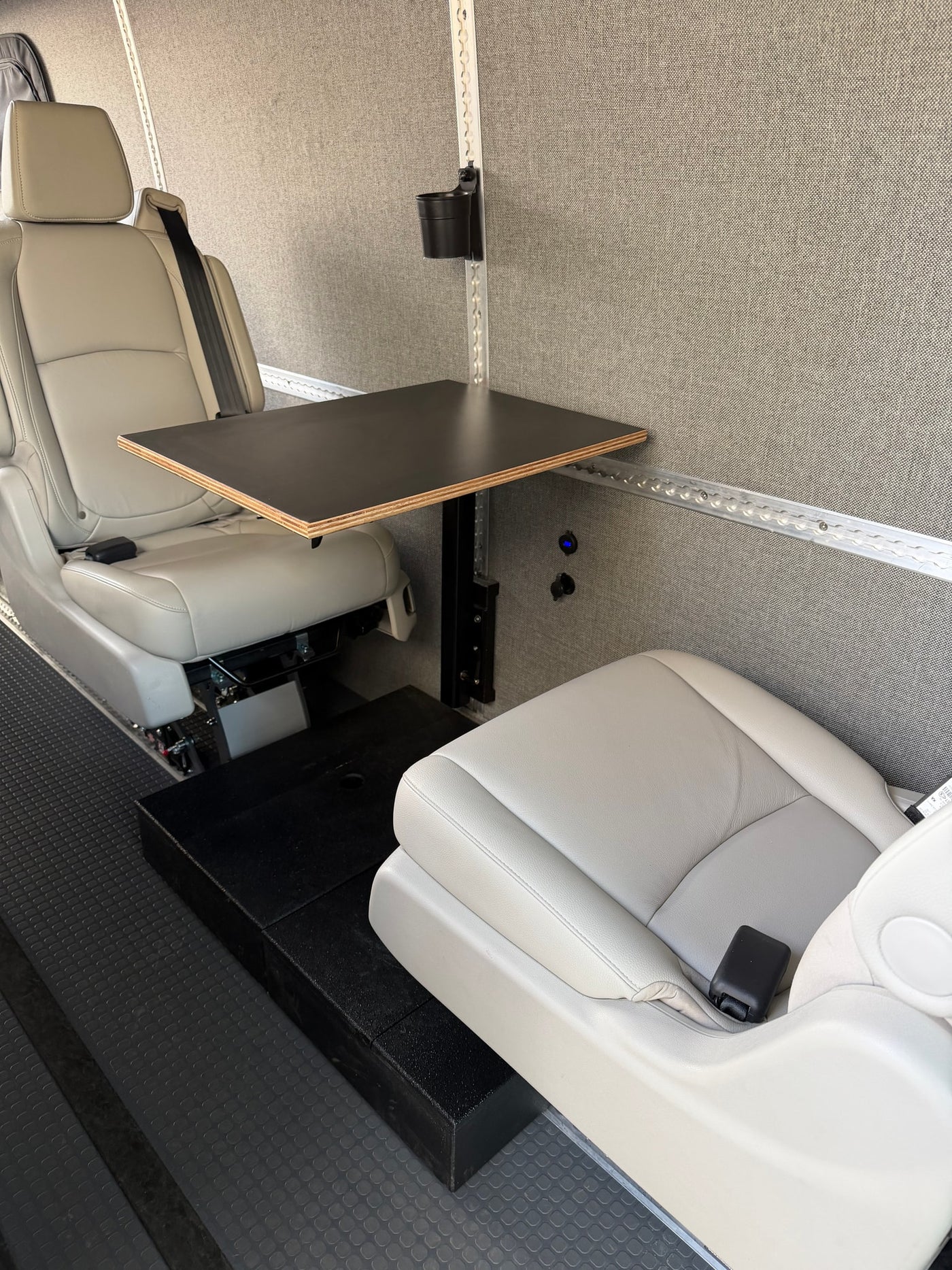 Comfortable RV rental interior with two light gray seats, a small table, and power outlets, ideal for a mobile workspace. — photo 14