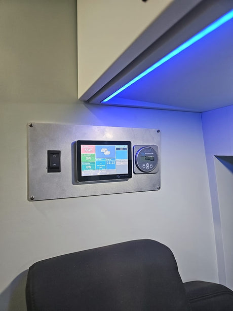 RV rental power management control panel. Displays 66W AC load, battery, and tank levels. Blue LED overhead.