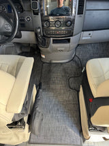 Spacious RV rental cockpit featuring light seats, a modern dashboard, and custom-fit grey floor mat.