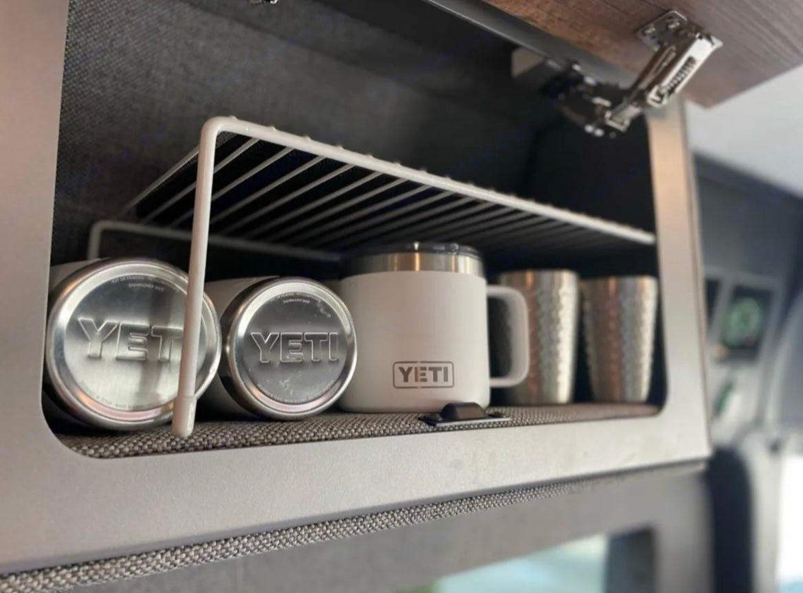 RV rental overhead cabinet with a wire shelf holds YETI cans, mugs & cups. Smart, organized storage for travel.