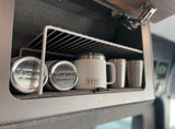 RV rental overhead cabinet with a wire shelf holds YETI cans, mugs & cups. Smart, organized storage for travel.
