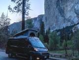 RV rental van with pop-top under El Capitan at dusk in Yosemite National Park, ready for adventure.