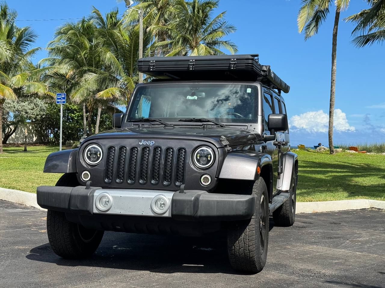 A gray Jeep Wrangler with a rooftop tent, ideal as an RV rental for beach camping & outdoor travel adventures. — photo 9