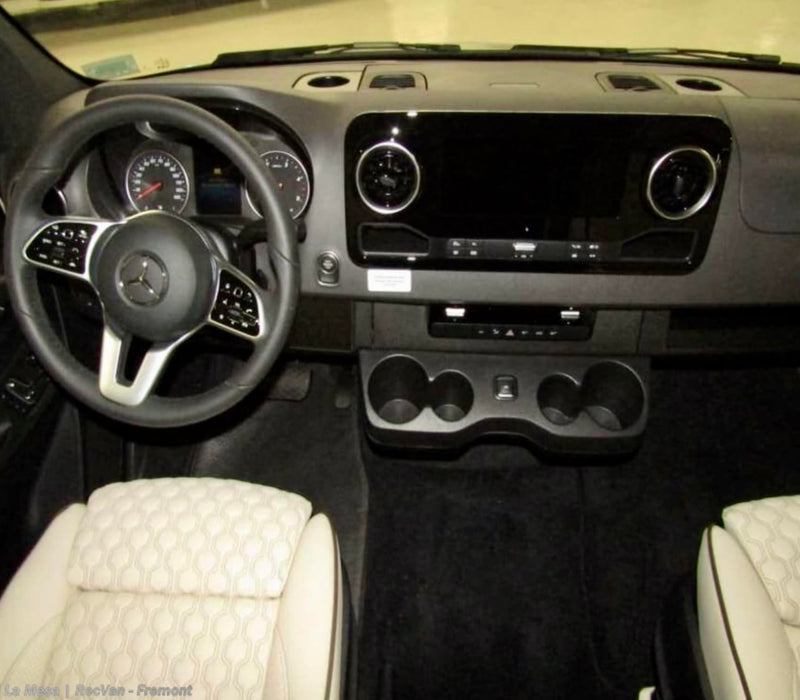 RV rental van's driver cockpit: Modern dashboard with a large screen, multi-function steering wheel, handy cup holders, and textured front seats. — photo 9