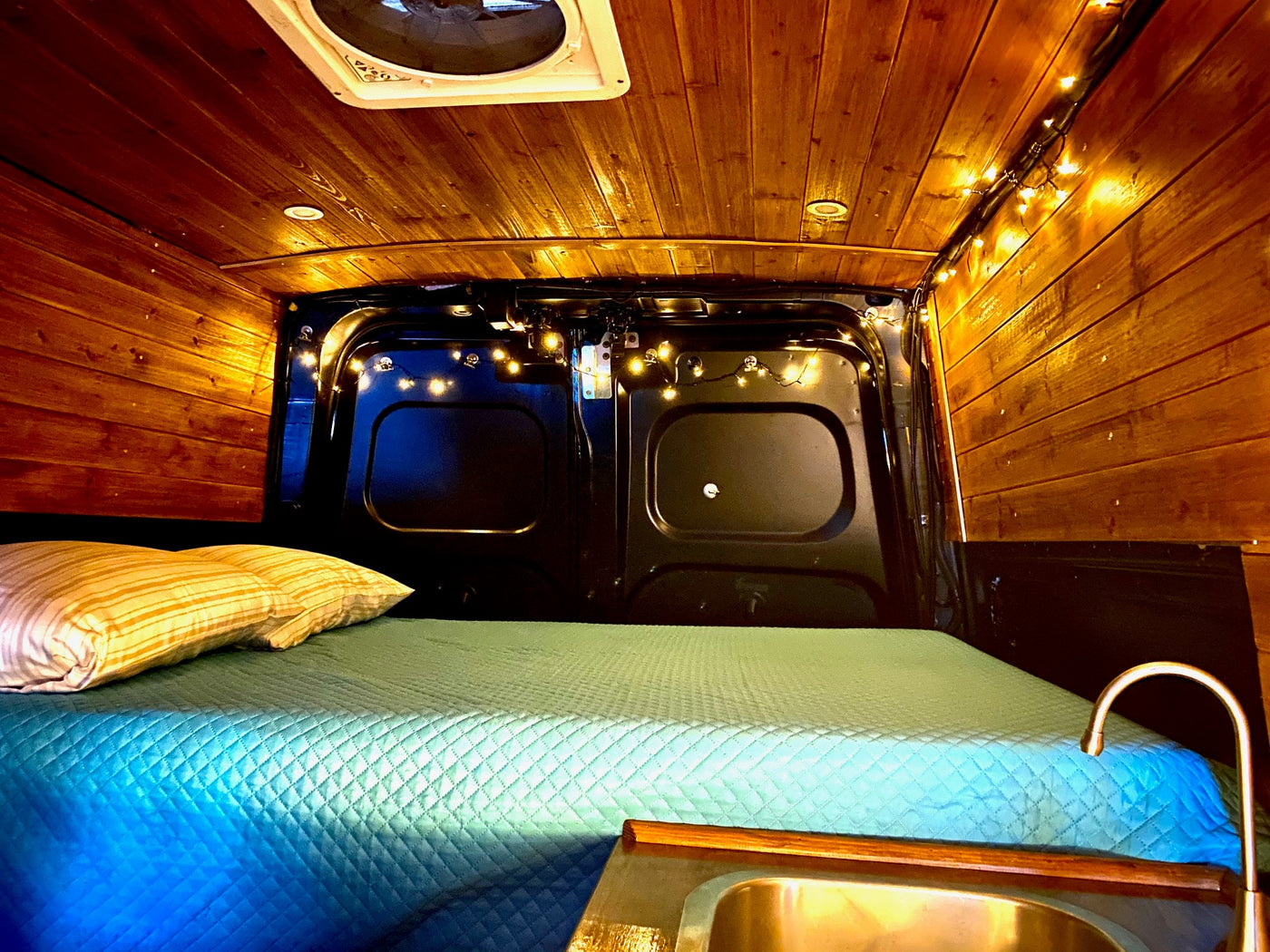  and small kitchenette. Ideal for your next adventure.|An RV rental camper van with its door open faces a marina with boats at sunset. Great for travel.|Cozy RV rental interior with warm wood paneling — photo 4