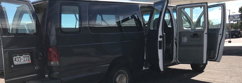  parked outside.|RV rental: View from rear of spacious van interior with folded bench seat and open cargo area.|A large — photo 5