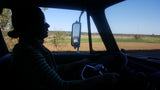 Scenic RV rental drive! Driver silhouetted at the wheel, with vast fields and blue sky visible through the windshield.