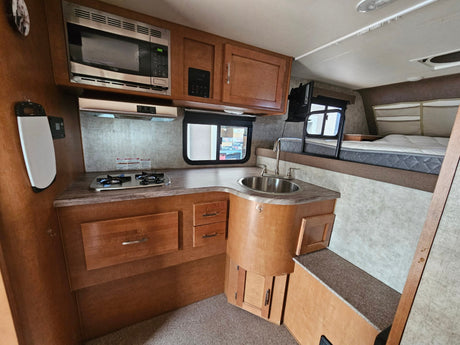  and cozy dinette seating for travel and adventure.|Inside an RV rental: functional kitchenette with microwave
