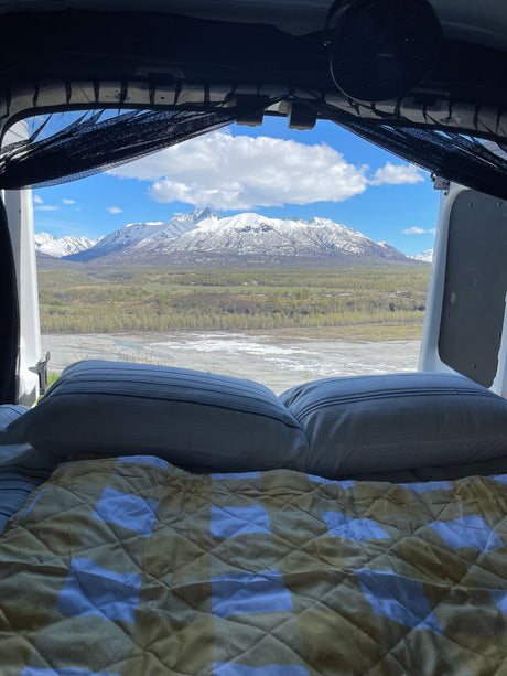 RV rental comfort: Wake up to stunning mountain views from your camper bed, overlooking a river valley.