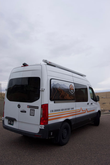 White Mercedes-Benz Sprinter camper van rv rental with striking Colorado Adventure Vans graphics for outdoor adventures.
