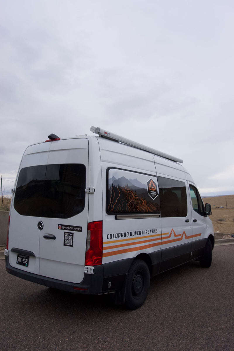  alongside custom wooden storage. Perfect for camper van travel.|RV rental interior: A compact — photo 14