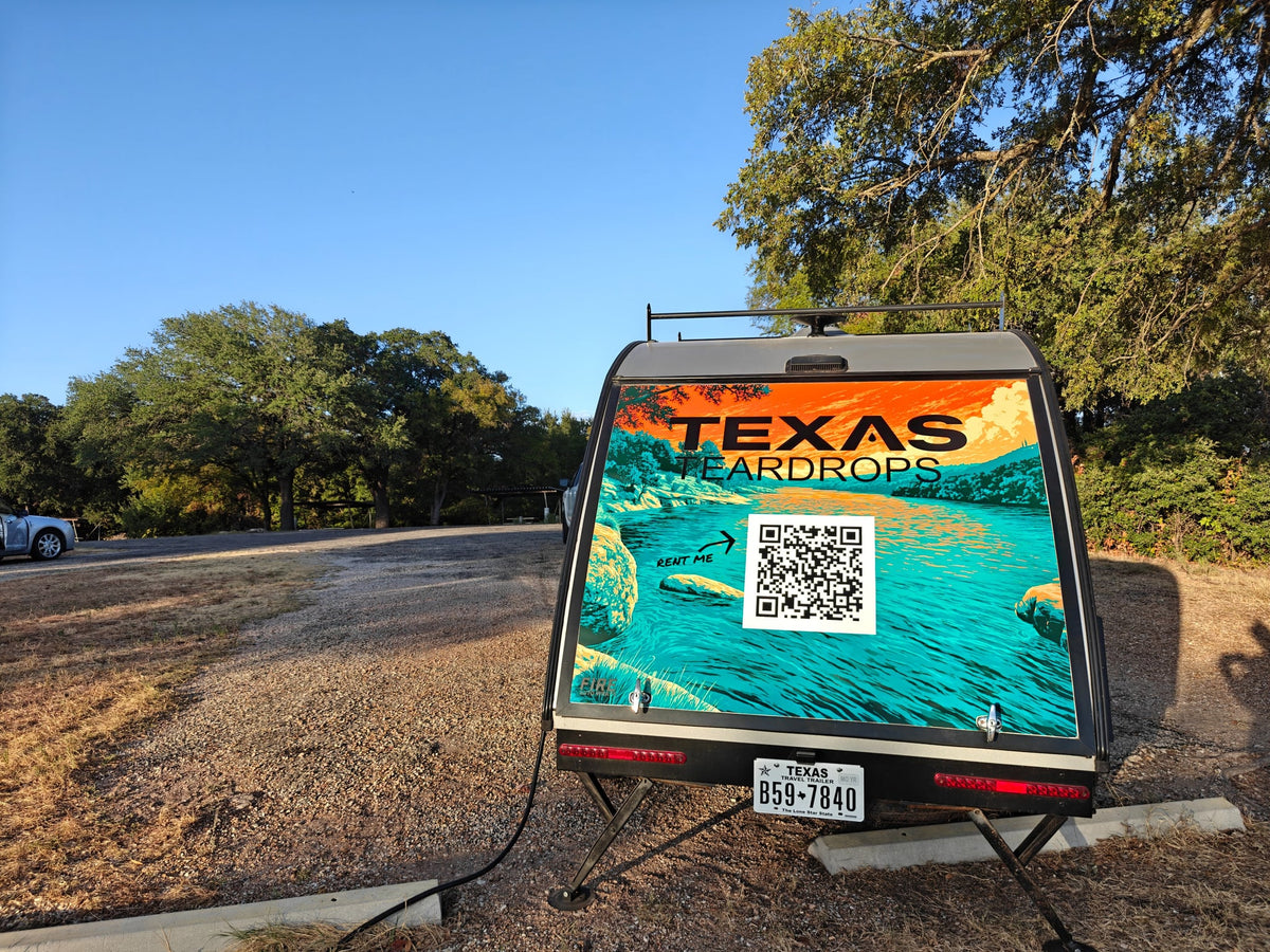  a comfy bed offers views of nature & a colorful camper.|Cozy RV rental bedroom featuring a comfy bed — photo 5