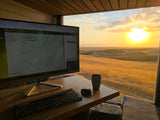 RV rental office with a stunning golden sunset view over rolling hills and vineyards, perfect for remote work.