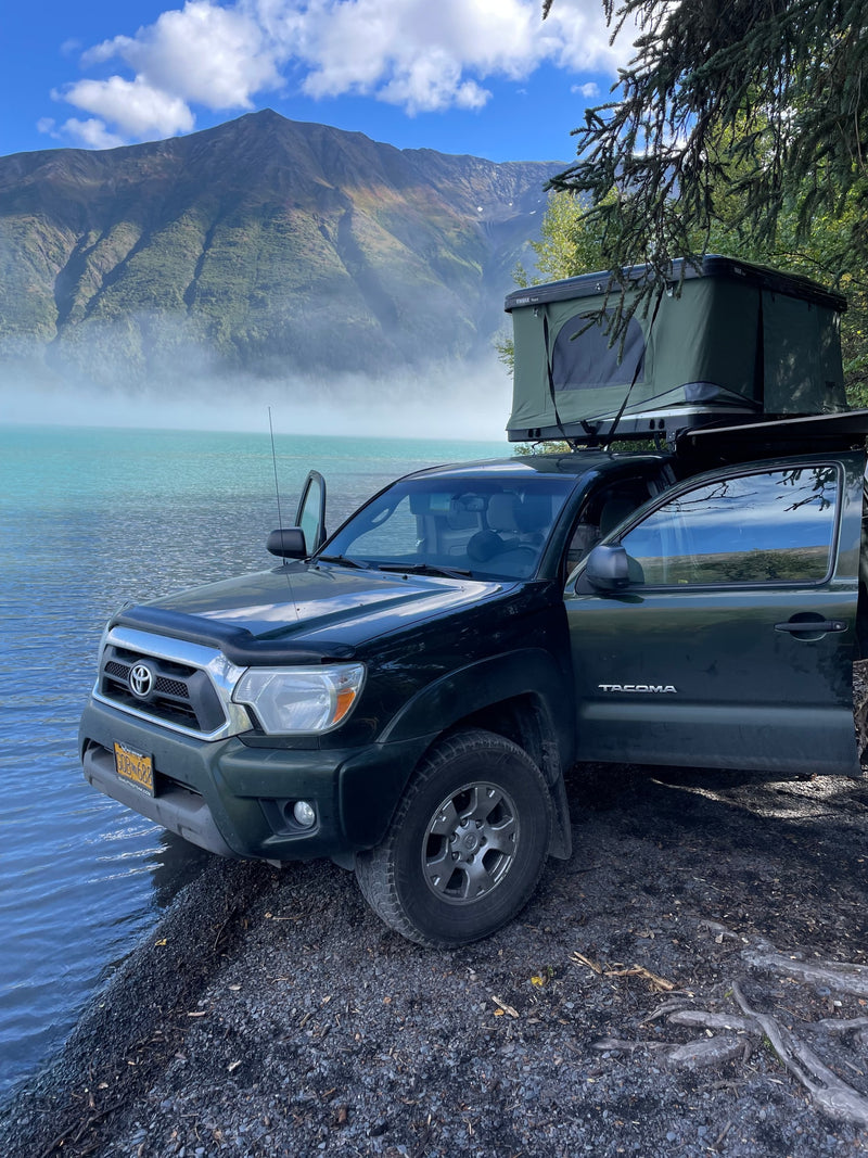 RV rental ready truck camping: Toyota Tacoma with rooftop tent beside a stunning misty lake and mountains. — photo 3