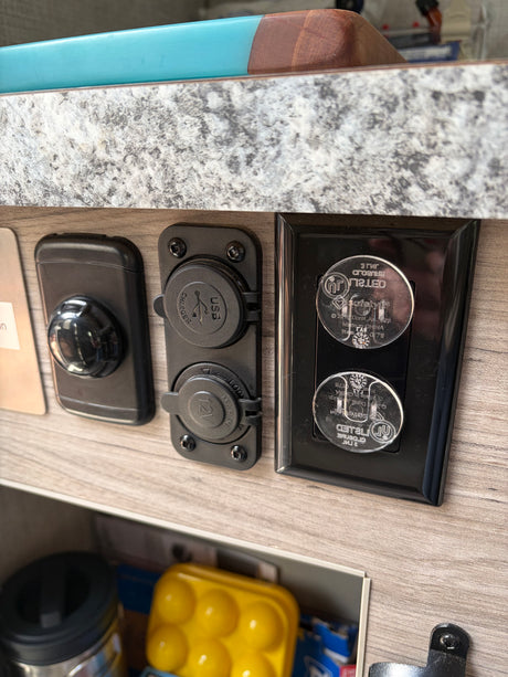 RV rental interior featuring essential charging ports (USB, 12V marine) and child-proofed AC power outlets for safety.