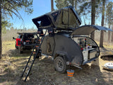 Enjoy off-grid camping with this RV rental: a teardrop trailer featuring a rooftop tent, outdoor kitchen, and an overland truck.