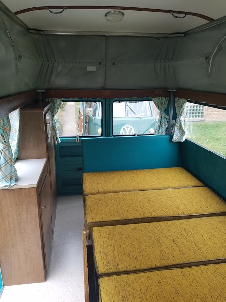  and teal walls.|This vintage RV rental interior features a functional kitchen with a two-burner stove — photo 10