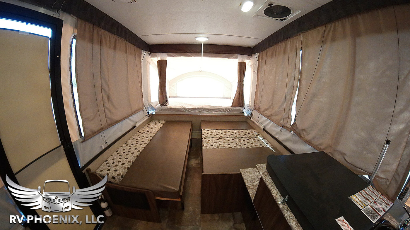 Spacious pop-up camper RV rental interior, showing convertible beds/benches & small counter. — photo 6