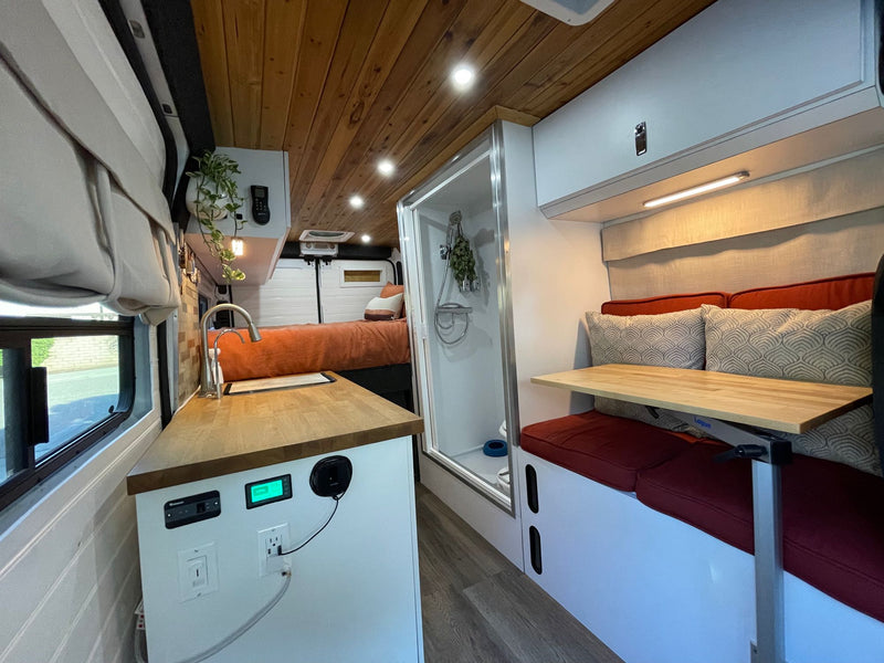 This cozy RV rental shows a modern camper van interior with a kitchen — photo 1